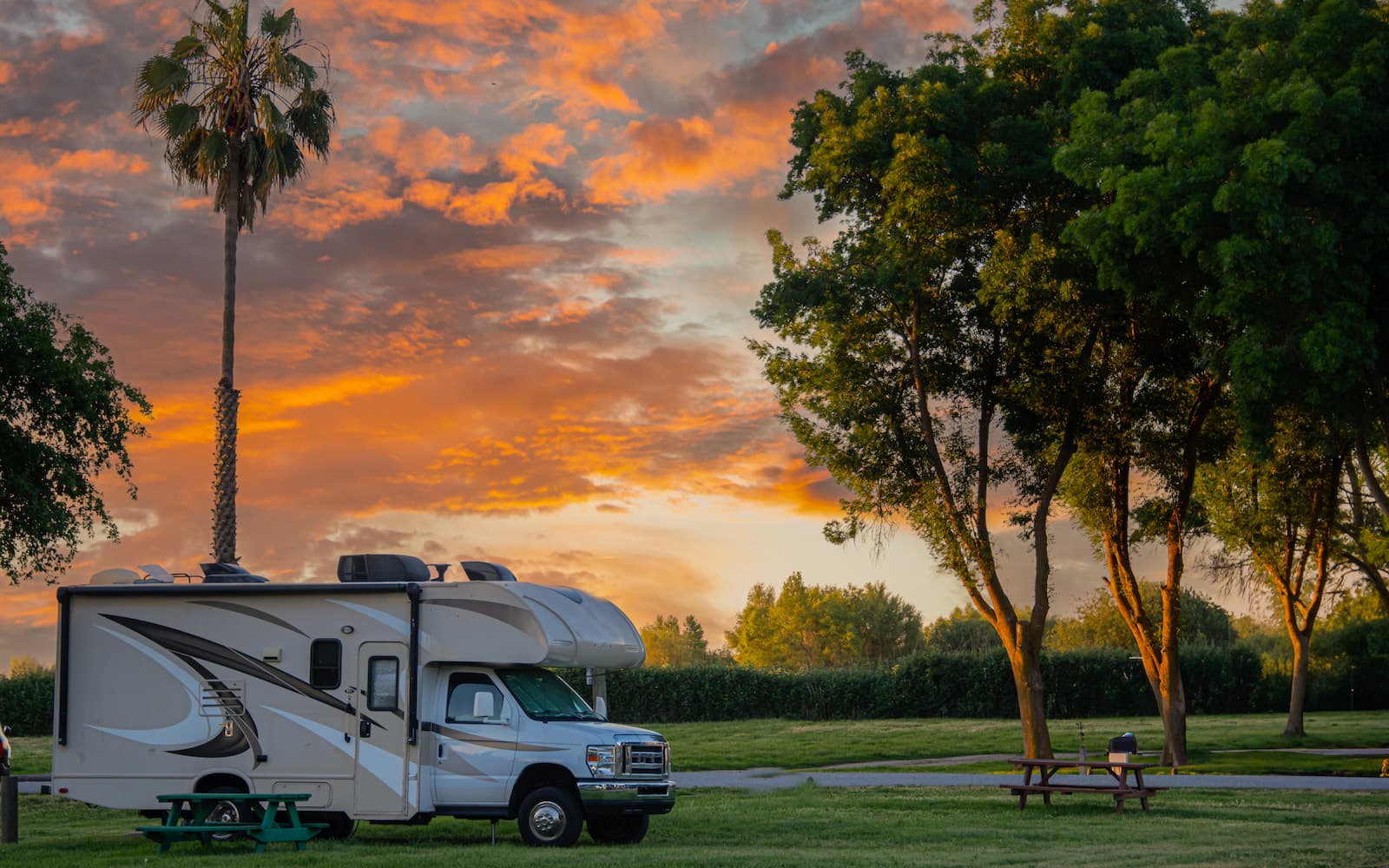 Modern camper van with pop-up roof parked on mountain road with scenic backdrop
